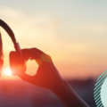 Person with headphones looking at the sun - demonstrating a customer listening to a brand tone of voice