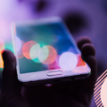 Hand holding a smartphone. Green screen with nothing featured on it.