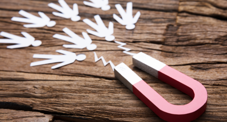 A magnet pulling in or attracting paper people