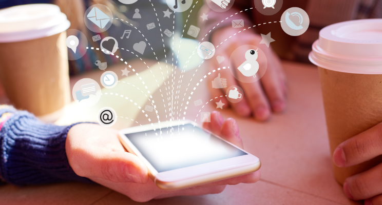 A smart phone with graphics dispersing out of it relating to social media and online buzz