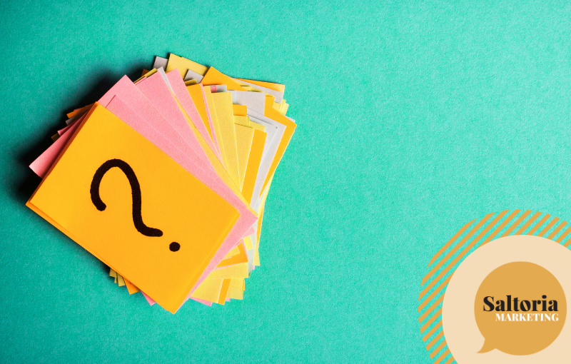 Coloured post-it on green table. There a handwritten question mark designed on the first post-it to simbolise questions to ask before you reposition your brand