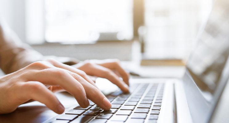 person typing on a laptop keyboard