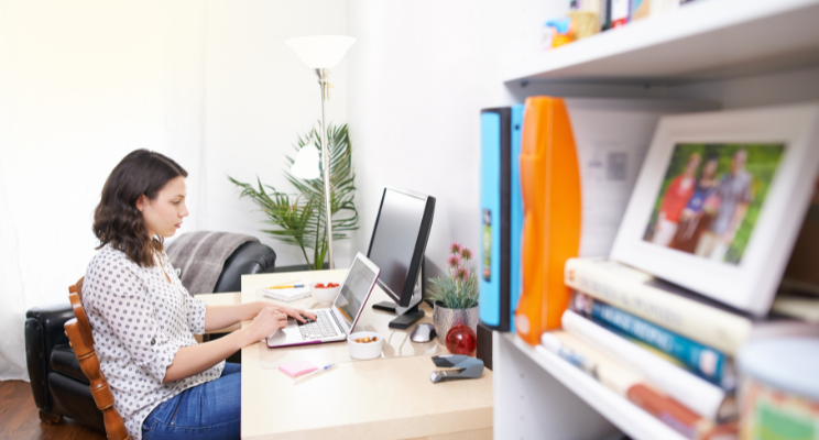 woman writing on a laptop in a home office